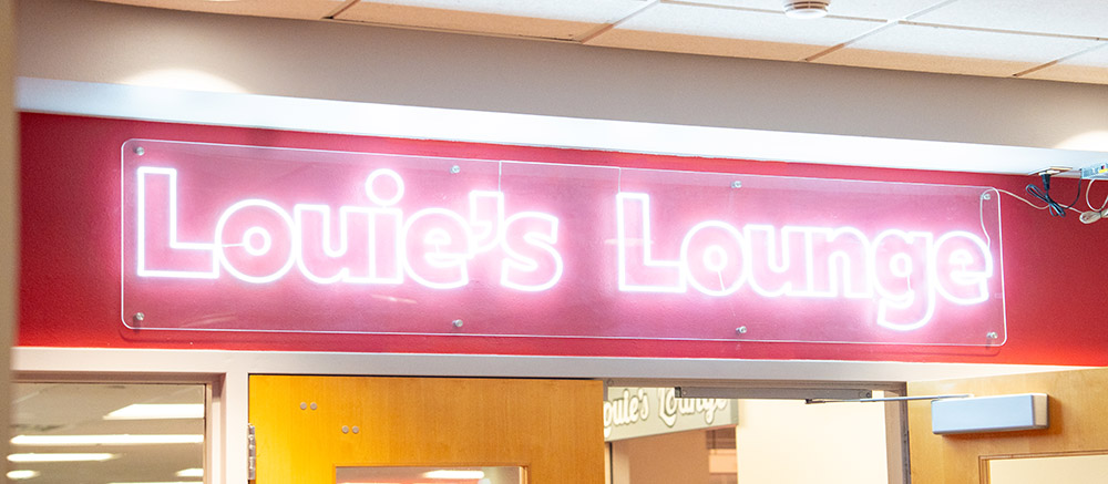 neon sign with the words louies lounge